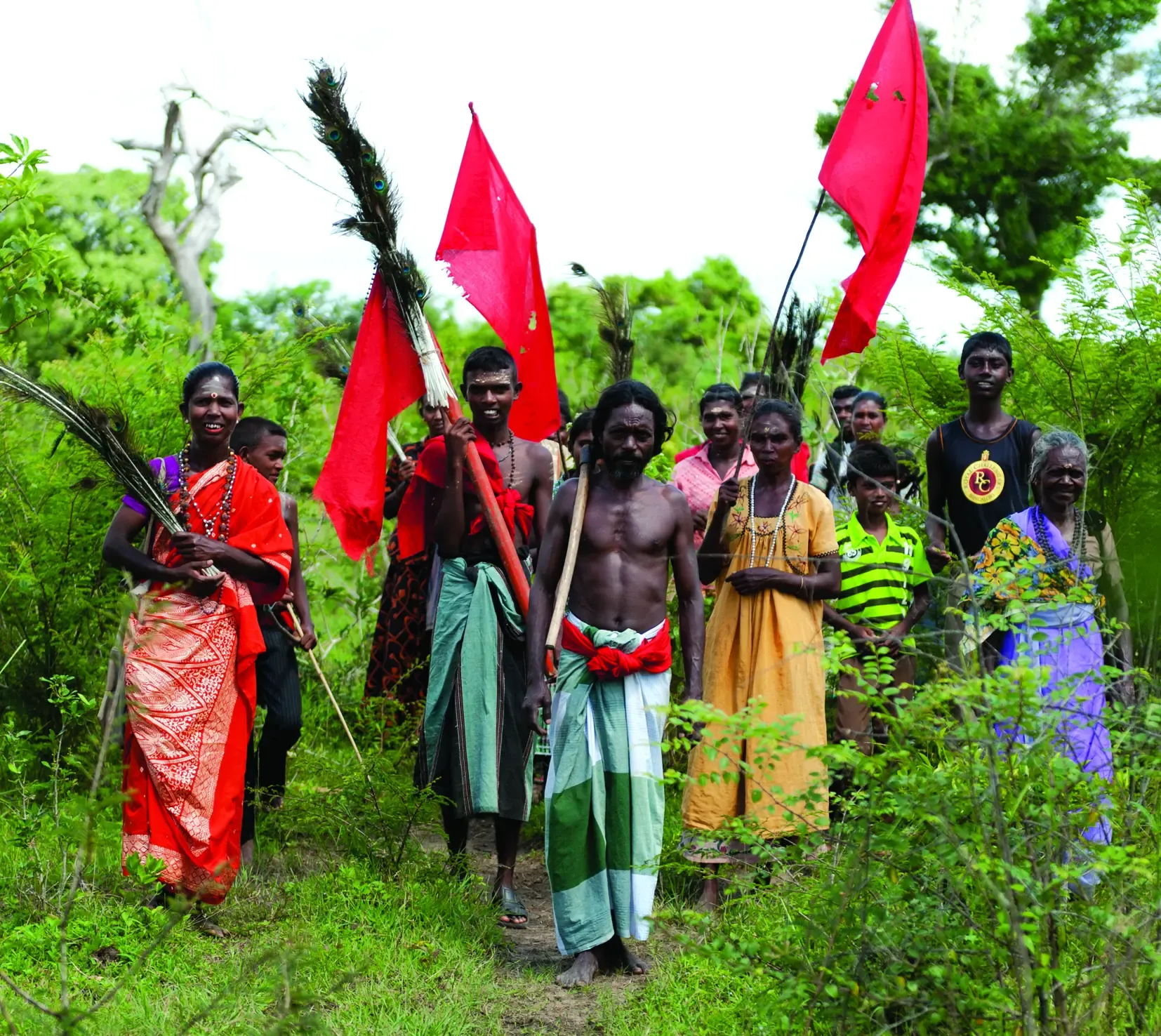 Indigenous Sri Lankan community walking in the nature waving flags 