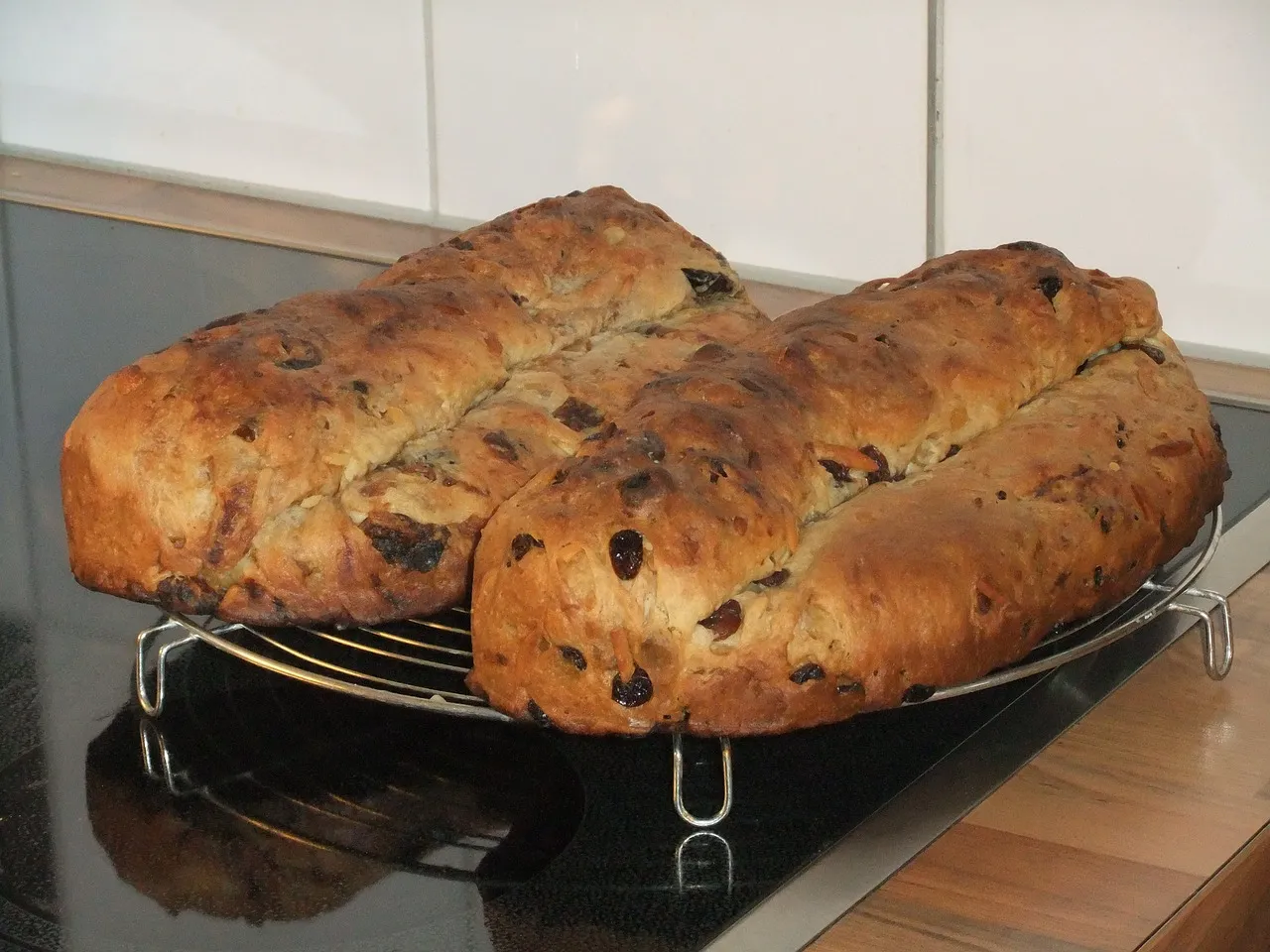 Two Christstollen breads on a cooling rack before icing