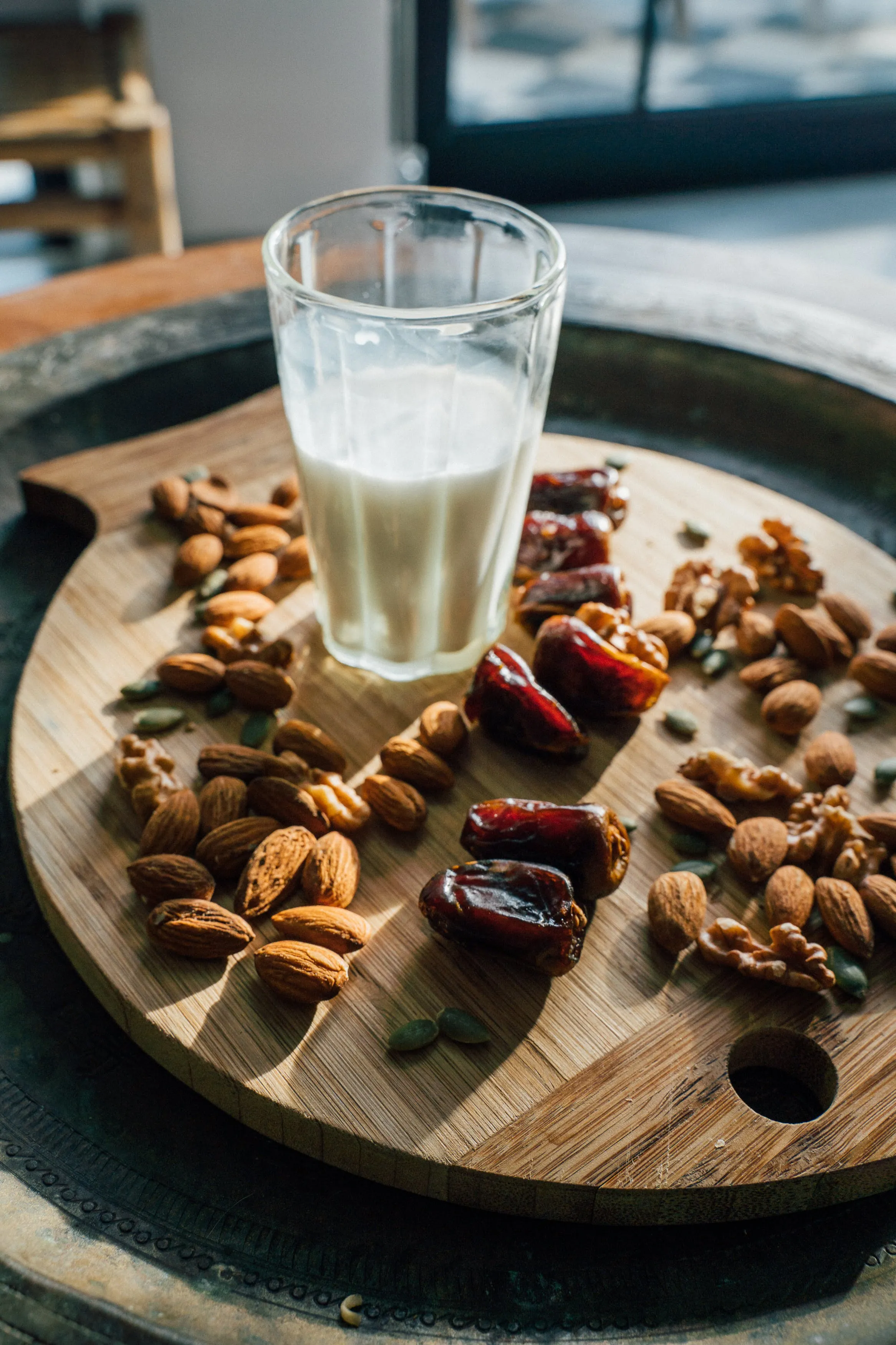 Nuts and a glass of milk on a wooden board
