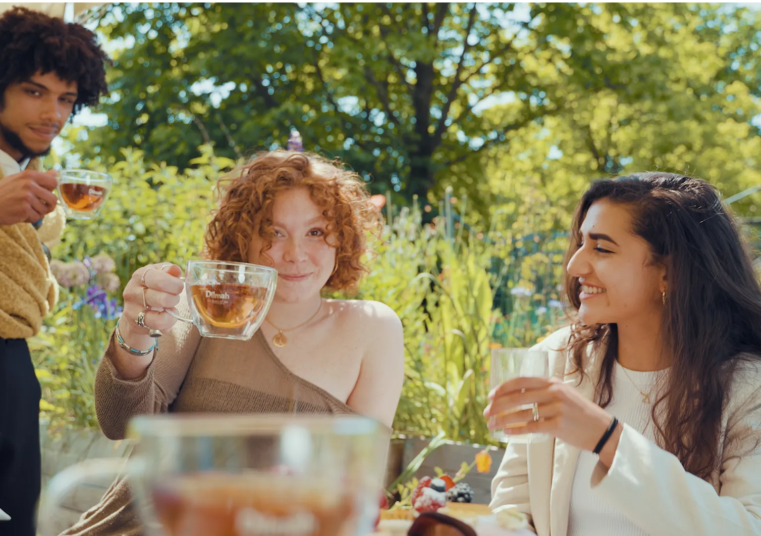 three young people drinking tea and enjoying each other's company