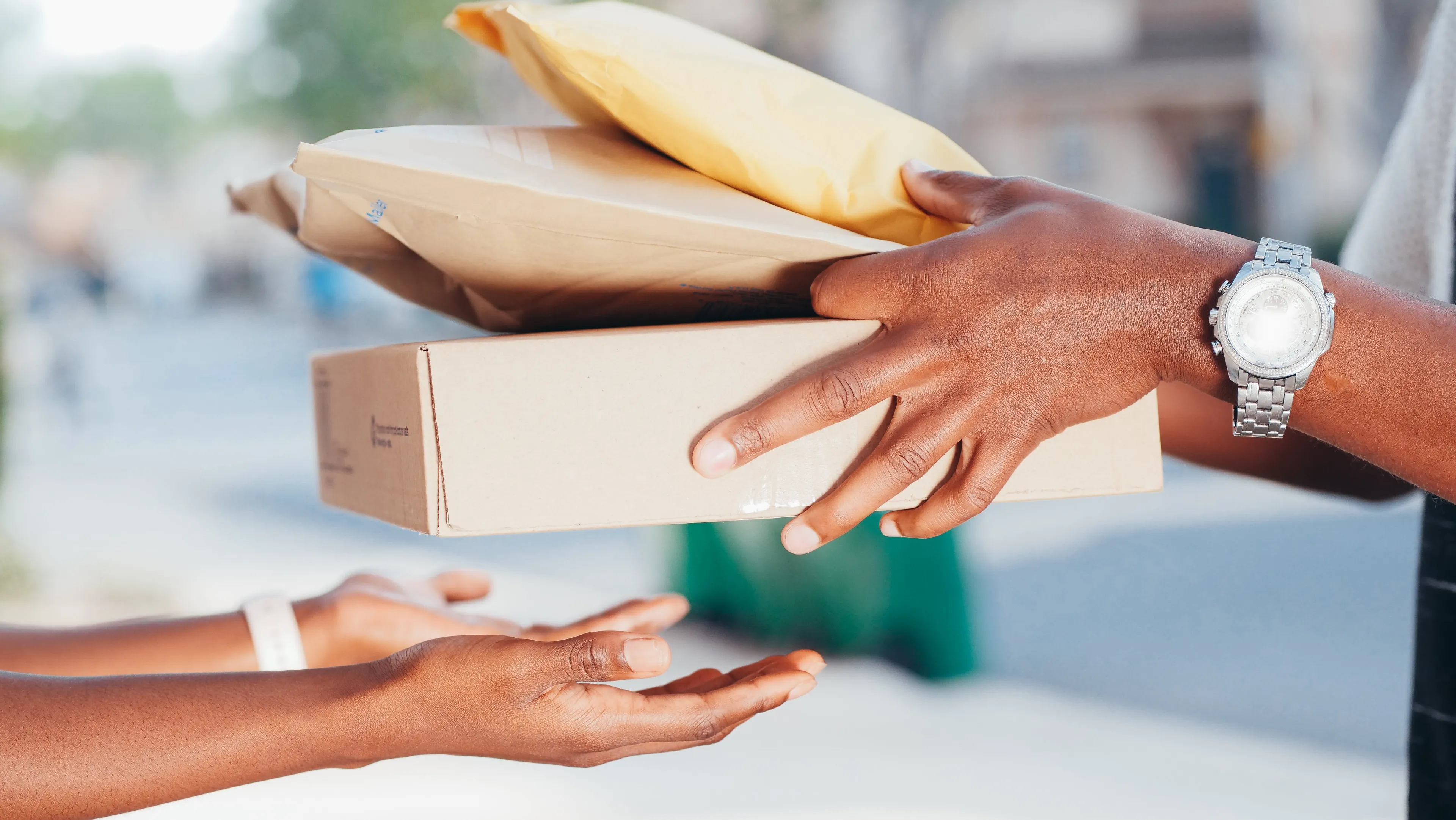 hands handing over 3 packages to another person