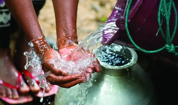Using clean water from a basket to wash hands