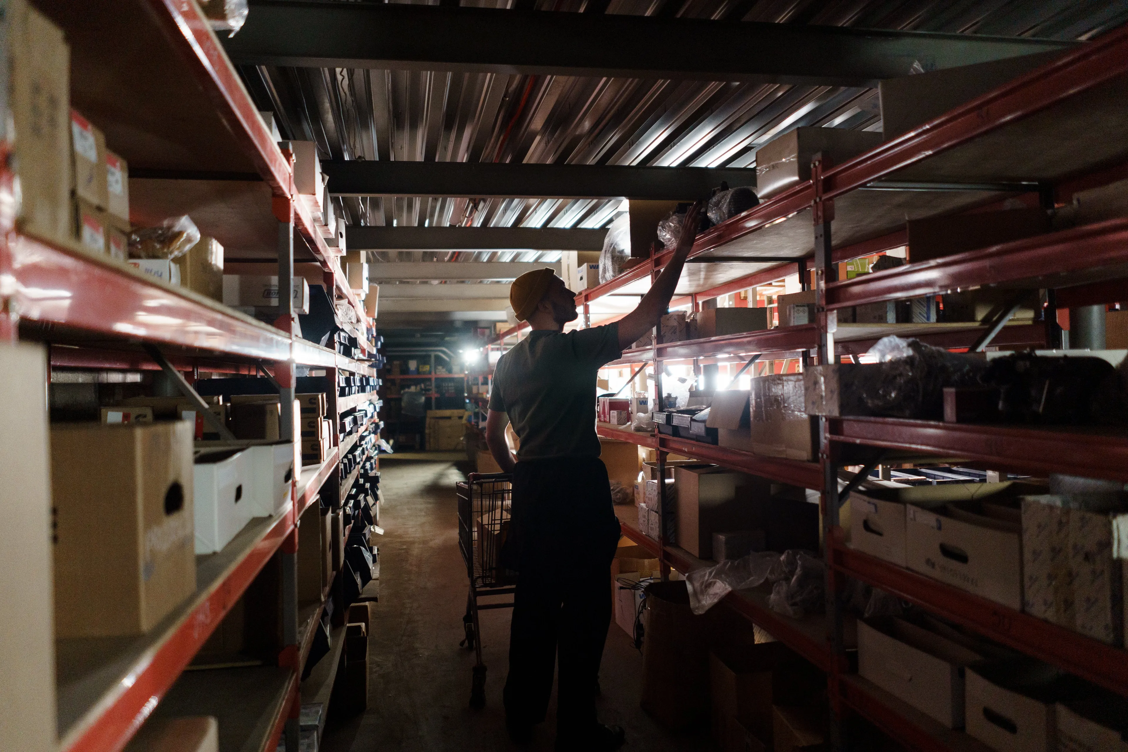 man doing his job at night, sorting out packages in a dark warehouse